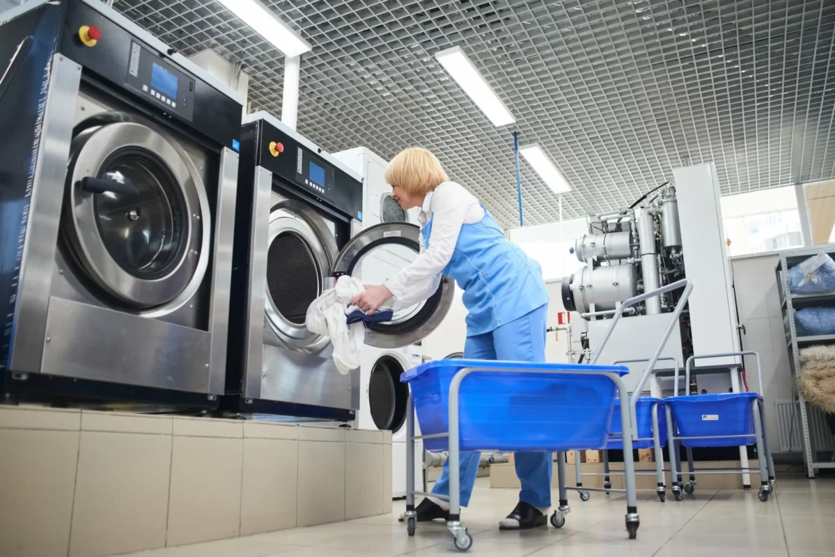 hands-loading-laundry-into-washing-machine-dry-cleaning-2-min-scaled